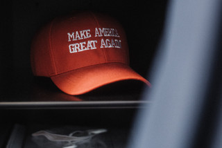 Eine rote Kappe mit der Aufschrift "Make America great agian" liegt in einem Regal.